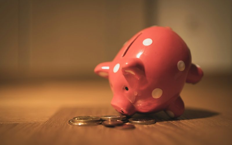 pink pig coin bank on brown wooden table